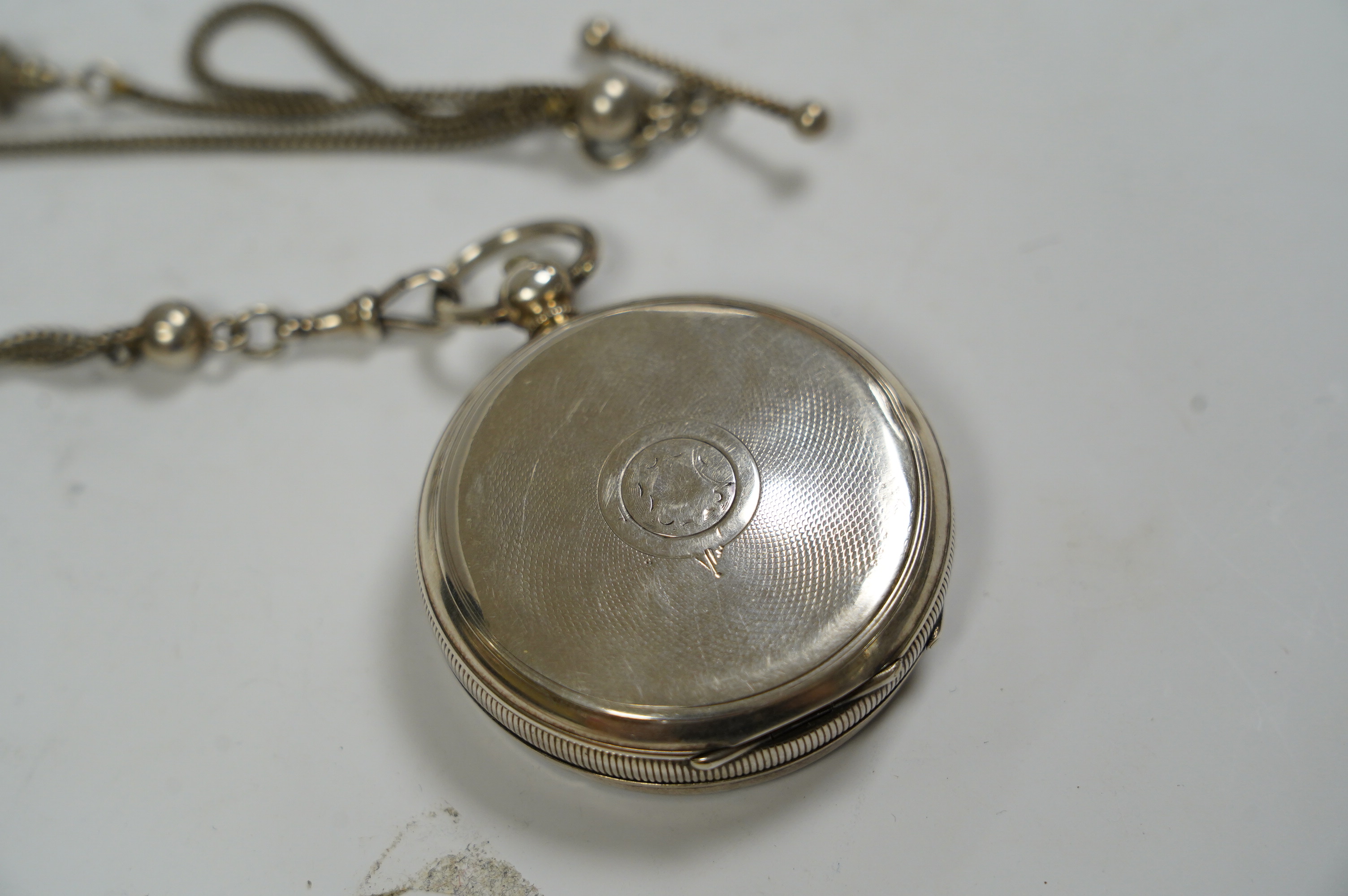 An early 20th century silver 'Acme Lever' open faced keywind pocket watch, retailed by Samuel, Manchester, with Roman dial and subsidiary seconds, case diameter 50mm, together with a white metal albertina. Condition - po